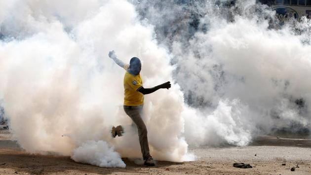 A man makes his way through rising tear gas fired by riot police officers to disperse supporters of Kenyan opposition leader in Nairobi. Police have said five people were killed by mobs that stoned them to death when they were caught stealing during the confrontations. But mortuary attendants and eyewitnesses said police shot them. (Baz Ratner / REUTERS)