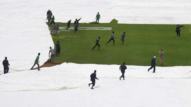 Grounds staff cover the pitch after play was delayed by rain at the start of the first Test between India and Sri Lanka at the Eden Gardens cricket stadium in Kolkata on November 16, 2017. (Dibyangshu Sarkar / AFP) Grounds staff cover the pitch after play was delayed by rain at the start of the first Test between India and Sri Lanka at the Eden Gardens cricket stadium in Kolkata on November 16, 2017. (Dibyangshu Sarkar / AFP)