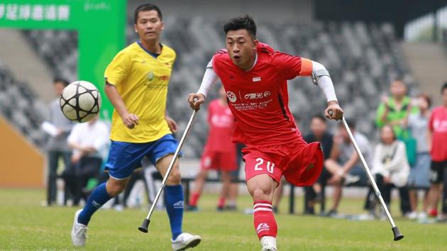 He Yiyi kicks the ball during a football match with a local team in Guangzhou, Guangdong province on November 12, 2017. The exploits of 21-year-old He Yiyi, who lost his leg to childhood cancer and uses crutches when playing, have earned him several nicknames including ‘Angel with Broken Wings’, ‘Ball King with One Leg’ and ‘Magic Boy’. (AFP) 