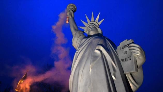 A replica of the Statue of Liberty emits smoke from the torch created by Danish artist Jens Galschiot and displayed at the Rheinaue park during the COP23 United Nations Climate Change Conference in Bonn, Germany on November 16, 2017. (Patrik Stollarz / AFP) 