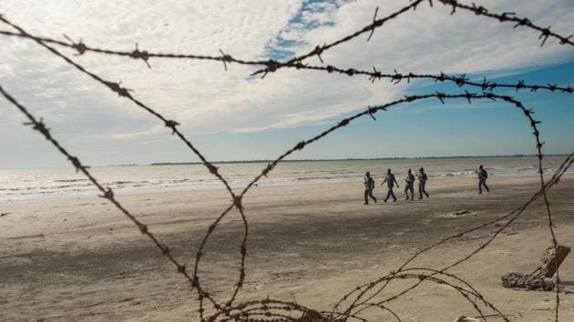 Myanmar border police patrol the beach near a makeshift camp in Rakhine state in Myanmar, where hundreds of Rohingya wait in makeshift camps before crossing over to Bangladesh, on November 12, 2017.  (Phyo Hein Kyaw / AFP) 