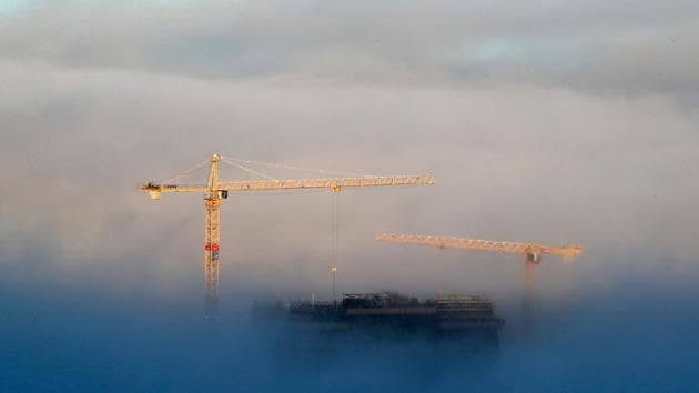 Building cranes and the top of the new Munch Museum under construction emerge above heavy fog covering central Oslo, Norway on November 15, 2017. (Cornelius Poppe / NTB scanpix / AFP) 