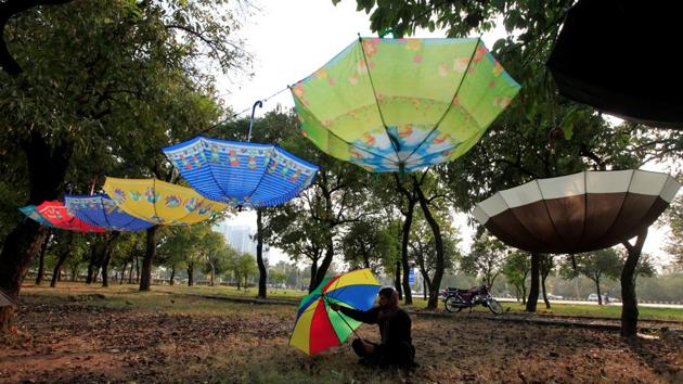 A man waits for customers while selling umbrellas along a roadside in Islamabad, Pakistan on November 16, 2017. (Faisal Mahmood / REUTERS) 