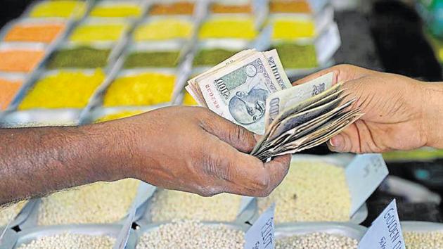 A customer hands over cash to a food grain merchant at a wholesale trading shop in Bangalore on February 28, 2017. India has seen its per capita GDP rise to USD 7,170 in 2017, from USD 6,690 last year, helping improve its rank by a position to 126th.(AFP File Photo)