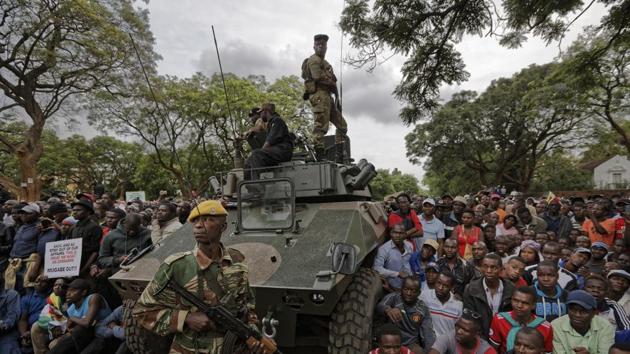 Army soldiers stand guard as protesters demanding President Robert Mugabe exit gather on the road leading to the State House in Harare, Zimbabwe, on Saturday. (AP) Army soldiers stand guard as protesters demanding President Robert Mugabe exit gather on the road leading to the State House in Harare, Zimbabwe, on Saturday. (AP)