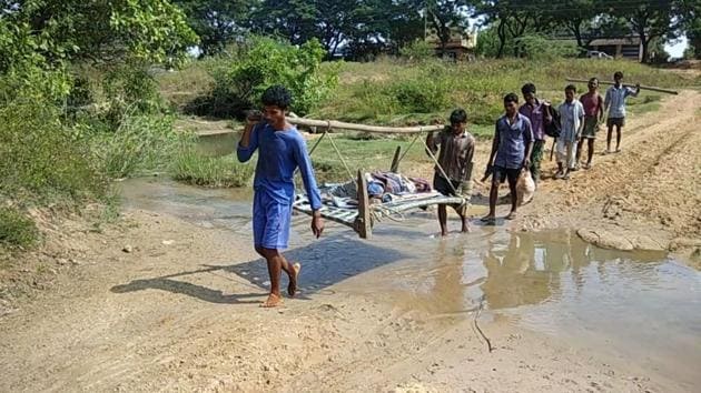 As the lack of road connectivity would not permit an ambulance into the village, Madakam Jogaiah’s sons converted his bed into a makeshift stretcher which they then carried on their shoulders through the dense woods. (HT Photo) As the lack of road connectivity would not permit an ambulance into the village, Madakam Jogaiah’s sons converted his bed into a makeshift stretcher which they then carried on their shoulders through the dense woods. (HT Photo)