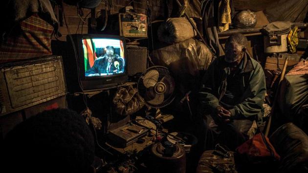 A man looks at a television set broadcasting the state address by President Mugabe in Harare on November 19, 2017. Many Zimbabweans expected Mugabe to resign swiftly after the army seized power but his speech alongside the uniformed generals who were behind the military intervention made no reference to the clamour for his resignation. (Zinyange Auntony / AFP) A man looks at a television set broadcasting the state address by President Mugabe in Harare on November 19, 2017. Many Zimbabweans expected Mugabe to resign swiftly after the army seized power but his speech alongside the uniformed generals who were behind the military intervention made no reference to the clamour for his resignation. (Zinyange Auntony / AFP)