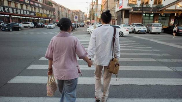 Gay couple Xiaoxiong (right) and Xiaojing walk on a street in Sheynyang, China, in July. (AFP) Gay couple Xiaoxiong (right) and Xiaojing walk on a street in Sheynyang, China, in July. (AFP)