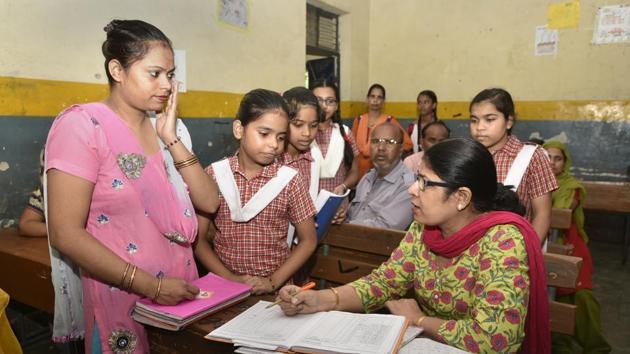 A teacher (R) in a Delhi government school with a parent at a special meeting.(Sushil Kumar/HT PHOTO)