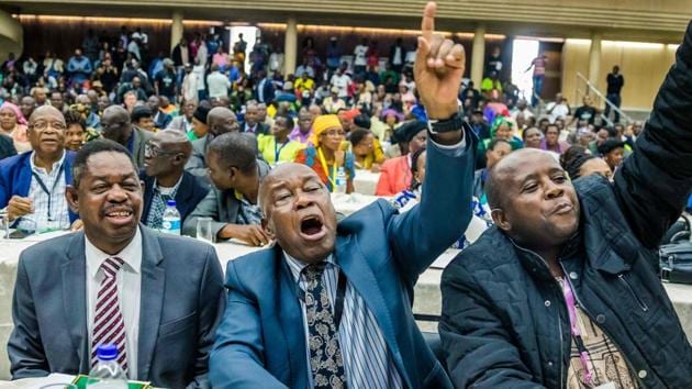War Veterans leader Christopher Mutsvangwa (C) celebrates the dismissal of the president of the ruling ZANU-PF party on November 19, 2017 in Harare. The ZANU-PF draft impeachment motion accuses Mugabe of being a “source of instability”, flouting the rule of law and presiding over an “unprecedented economic tailspin” in the last 15 years. (Jekesai Njikizana / AFP) War Veterans leader Christopher Mutsvangwa (C) celebrates the dismissal of the president of the ruling ZANU-PF party on November 19, 2017 in Harare. The ZANU-PF draft impeachment motion accuses Mugabe of being a “source of instability”, flouting the rule of law and presiding over an “unprecedented economic tailspin” in the last 15 years. (Jekesai Njikizana / AFP)