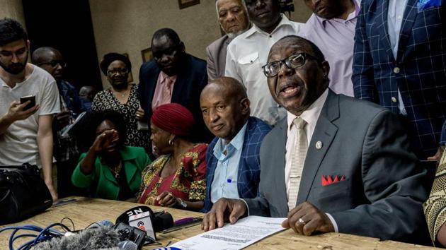 ZANU-PF spokesperson Simon Khama Moyo (R) reads the outcome of the caucus meeting on November 20, 2017 at party headquarters in Harare. Impeachment would be an ignominious end to the career of the “Grand Old Man” of African politics, once lauded as an anti-colonial hero and the only leader Zimbabwe has known since it gained independence from Britain in 1980. (Zinyange Auntony / AFP) ZANU-PF spokesperson Simon Khama Moyo (R) reads the outcome of the caucus meeting on November 20, 2017 at party headquarters in Harare. Impeachment would be an ignominious end to the career of the “Grand Old Man” of African politics, once lauded as an anti-colonial hero and the only leader Zimbabwe has known since it gained independence from Britain in 1980. (Zinyange Auntony / AFP)