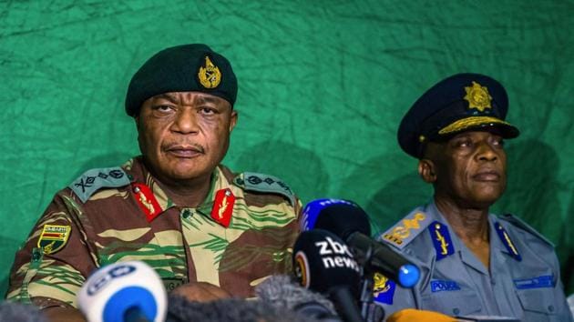 Zimbabwe’s Army chief Constatntino Guveya Chiwenga (L) speaks during a press conference on November 20, 2017 in Harare, Zimbabwe. Chiwenga said that progress had been made in talks towards an apparent deal over Mugabe’s exit. He also said the president was in touch with Emmerson Mnangagwa, the ousted vice president whose sacking triggered the military takeover and Mugabe’s loss of power. (Jekesai Njikizana / AFP) Zimbabwe’s Army chief Constatntino Guveya Chiwenga (L) speaks during a press conference on November 20, 2017 in Harare, Zimbabwe. Chiwenga said that progress had been made in talks towards an apparent deal over Mugabe’s exit. He also said the president was in touch with Emmerson Mnangagwa, the ousted vice president whose sacking triggered the military takeover and Mugabe’s loss of power. (Jekesai Njikizana / AFP)