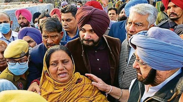 Punjab CM Amarinder Singh (R) consoles Manjeet Kaur, wife of firefighter Raj Kumar whose body was recovered from the rubble, in Ludhiana on Tuesday.(Gurpreet Singh/HT)