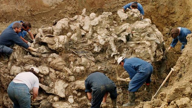 A September 18, 1996 photo shows International War Crimes Tribunal investigators clearing away soil and debris from dozens of Srebrenica victims buried in a mass grave near the village of Pilica. Mladic’s lawyers argue that Sarajevo was a legitimate military target as the main bastion of Muslim-led Bosnian government forces. They also assert that Mladic left Srebrenica shortly before Serb fighters began executing Muslim detainees and was later shocked at the discovery. (Staton R. Winter / AP) A September 18, 1996 photo shows International War Crimes Tribunal investigators clearing away soil and debris from dozens of Srebrenica victims buried in a mass grave near the village of Pilica. Mladic’s lawyers argue that Sarajevo was a legitimate military target as the main bastion of Muslim-led Bosnian government forces. They also assert that Mladic left Srebrenica shortly before Serb fighters began executing Muslim detainees and was later shocked at the discovery. (Staton R. Winter / AP)