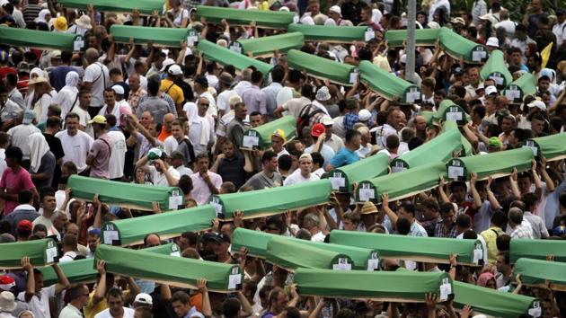 People carry coffins prior to a mass burial at the Potocari memorial cemetery near Srebrenica on July 11, 2011. Over the years, the International Commission of Missing Persons has identified some 6,900 remains of Srebrenica victims through DNA analysis. (Marko Drobnjakovic / AP) People carry coffins prior to a mass burial at the Potocari memorial cemetery near Srebrenica on July 11, 2011. Over the years, the International Commission of Missing Persons has identified some 6,900 remains of Srebrenica victims through DNA analysis. (Marko Drobnjakovic / AP)