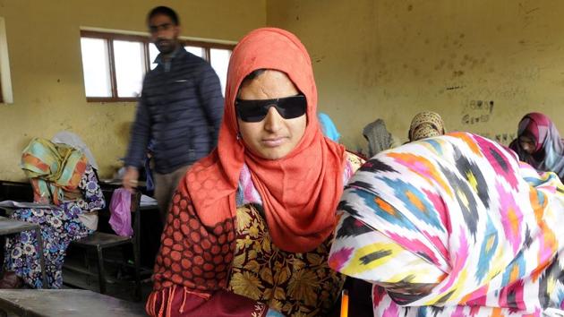 A girl helping Insha Mushtaq write her paper at the examination centre in Shopian town of South Kashmir.(Waseem Andrabi/HT Photo)