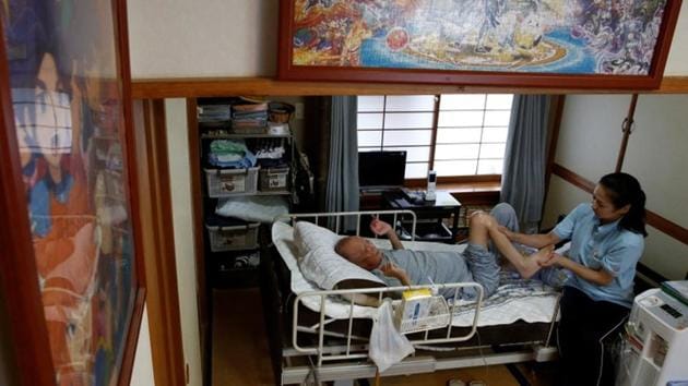 Mitsuru Niinuma, 69, who has terminal lung cancer, is massaged by a therapist in his room which was decorated with puzzles, put together by Niinuma's grandson. The bed shortage stems partly from long hospital stays, which ran 16.5 days on average in 2015, a study by the Organisation for Economic Cooperation and Development  showed. (Kim Kyung-Hoon / REUTERS) 