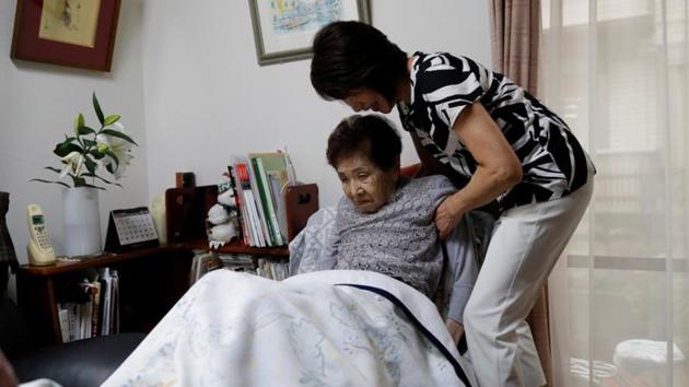 Yasuda Toyoko, 95, who has stomach cancer and dementia, is helped by her daughter, Terada. Terada said she decided to take care of her mother because she believed being in hospital weakened her and worsened her dementia. (Kim Kyung-Hoon / REUTERS) 