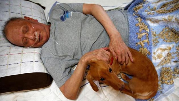Mitsuru Niinuma, pats his pet dog Rin at his home. He chose to stay at home in order to spend more time with his grandson and his beloved dachshund, Rin. “Home care allows people to use their abilities to their fullest for as long as possible,” he said. (Kim Kyung-Hoon / REUTERS) 