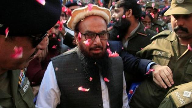 Hafiz Saeed is showered with flower petals as he walks to court before an order on his release from house arrest in Lahore, Pakistan.(Reuters) Hafiz Saeed is showered with flower petals as he walks to court before an order on his release from house arrest in Lahore, Pakistan.(Reuters)