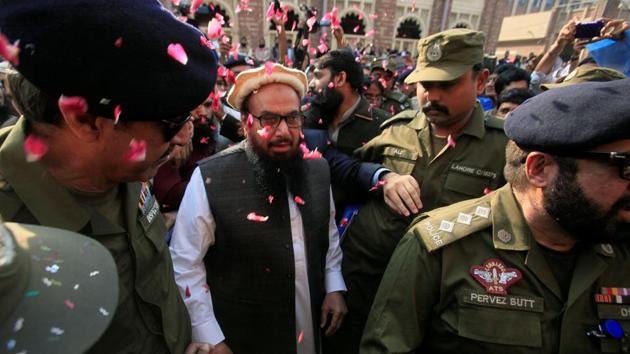 Hafiz Saeed is showered with flower petals as he walks to court before a Pakistani court ordered his release from house arrest in Lahore, Pakistan.(REUTERS) Hafiz Saeed is showered with flower petals as he walks to court before a Pakistani court ordered his release from house arrest in Lahore, Pakistan.(REUTERS)