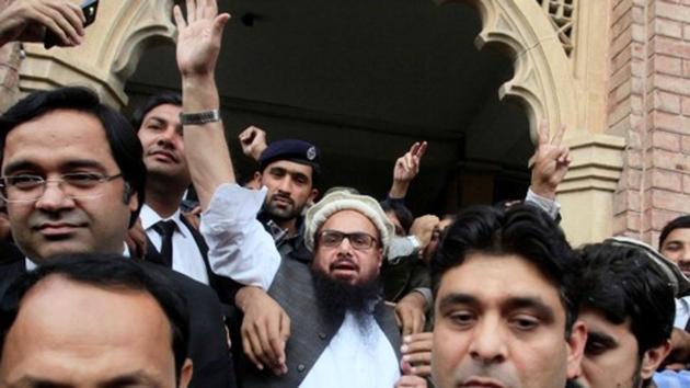 Hafiz Saeed (centre) reacts to supporters as he walks out of court after an order for his release from house arrest in Lahore, Pakistan.(Reuters)