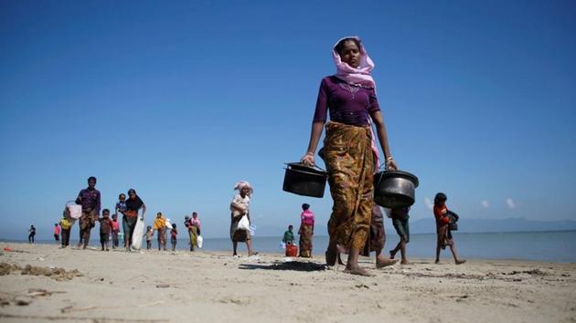 Rohingya refugees walk on the shore as they arrive on a makeshift boat after crossing the Bangladesh-Myanmar border near Cox's Bazar on November 9, 2017. (Reuters) Rohingya refugees walk on the shore as they arrive on a makeshift boat after crossing the Bangladesh-Myanmar border near Cox's Bazar on November 9, 2017. (Reuters)