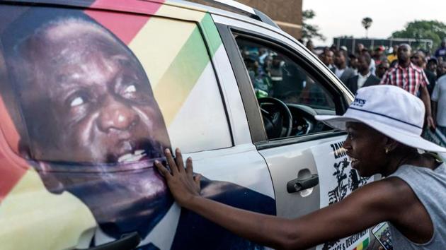 A supporter of Emmerson Dambudzo Mnangagwa touches an image of the politician glued on a SUV at the ZANU-PF headquarter in Harare, on November 22, 2017. (AFP Photo) A supporter of Emmerson Dambudzo Mnangagwa touches an image of the politician glued on a SUV at the ZANU-PF headquarter in Harare, on November 22, 2017. (AFP Photo)