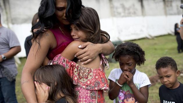 Female inmate Rossana Goncalves cries with her children by her side, as they reunite on the sidelines of competing in the pageant at Talavera Bruce prison in Rio de Janeiro. The three finalists won an electric fan, an iron and a fan respectively. (Silvia Izquierdo / AP) Female inmate Rossana Goncalves cries with her children by her side, as they reunite on the sidelines of competing in the pageant at Talavera Bruce prison in Rio de Janeiro. The three finalists won an electric fan, an iron and a fan respectively. (Silvia Izquierdo / AP)