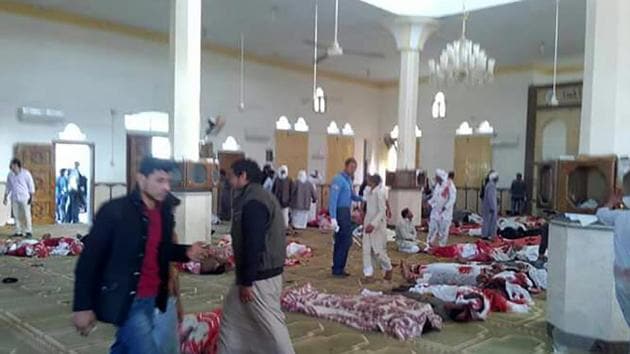 Egyptians walk past bodies following a gun and bombing attack at the Rawda mosque on Friday. (AFP Photo) Egyptians walk past bodies following a gun and bombing attack at the Rawda mosque on Friday. (AFP Photo)