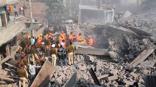 Rescue operations seen underway on the day the building collapsed in Ludhiana on November 20, 2017. The multi-storey factory had caught fire before collapsing hours later. Poisonous gases erupting out of the factory had converted the area into a gas chamber, forcing rescuers to wear masks as they struggled against time to extricate survivors.  (Gurpreet Singh / HT Photo) 