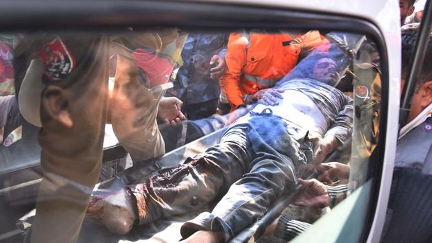 An injured person is taken to a hospital after the collapse. The fire mishap has also raised questions over the functioning of state health department that had failed to utilise the government operated 108 ambulance services to full capacity. Instead, ambulances of a private firm were used to ferry 12 of the 13 dead from the collapse site to hospitals in the city. (Gurpreet Singh / HT Photo) 