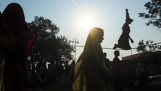 A girl walks on the tight rope to entertain people at the Sonepur mela in Bihar. (Pratik Chorge / HT Photo)