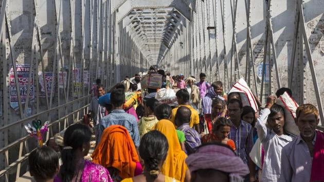 Devotees walk on the bridge to reach Sonepur mela in Bihar. Modi said the state government has gradually transformed the cattle fair into a cultural festival. (Pratik Chorge / HT Photo)