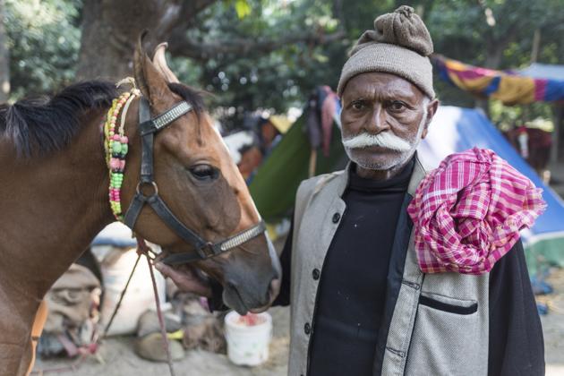 Lalbabu Jadhav, a horse trader from Betiya district, Bihar poses for a photograph with his horse at the Sonepur Mela grounds. Horse trading has picked up over the years and several traders come to the venue from Rajasthan, Balhotra, Khagariya, Balia and Punjab. (Pratik Chorge / HT Photo)