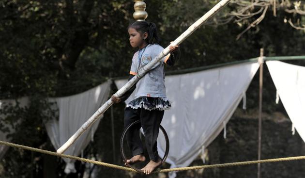 A child performer shows her balancing skill at the second day of Chandigarh Carnival on Saturday. (Ravi Kumar/HT)