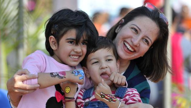 A lady with kids enjoying at the Chandigarh Carnival on Saturday. The three-day long carnival will host a range of competitions for people of all age groups. (Ravi Kumar/HT)