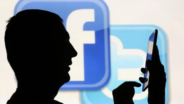 A man is silhouetted as he uses a mini tablet computer while standing in front of a video screen with the Facebook and Twitter logos. (Reuters/Representative image) A man is silhouetted as he uses a mini tablet computer while standing in front of a video screen with the Facebook and Twitter logos. (Reuters/Representative image)