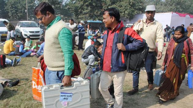 Polling officials with election voting machines in Ghaziabad on Saturday.(PTI Photo)
