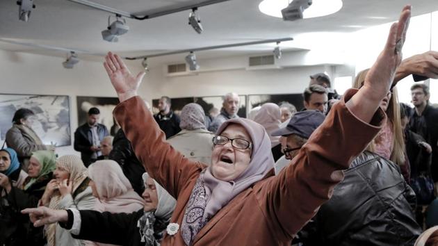 A Bosnian woman raises her arms upon hearing the sentence at the end of former Bosnian Serb military chief Gen. Ratko Mladic's trial at the memorial center in Potocari, near Srebrenica on Wednesday. (Amel Emric / AP) A Bosnian woman raises her arms upon hearing the sentence at the end of former Bosnian Serb military chief Gen. Ratko Mladic's trial at the memorial center in Potocari, near Srebrenica on Wednesday. (Amel Emric / AP)