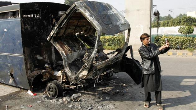 A passerby takes a selfie in front of a police prison van destroyed during clashes with police near the Faizabad junction in Islamabad, Pakistan. (Reuters) A passerby takes a selfie in front of a police prison van destroyed during clashes with police near the Faizabad junction in Islamabad, Pakistan. (Reuters)
