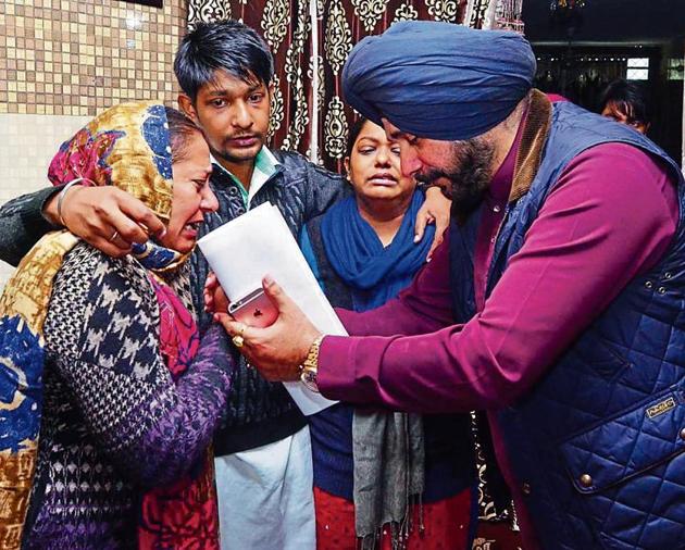 Punjab local bodies minister Navjot Singh Sidhu consoling deceased firefighter Sumohan Gill’s wife Venus Gill (left), son Sahil Gill and daughter Shanaz Gill in Amritsar on Sunday. (Sameer Sehgal/HT) Punjab local bodies minister Navjot Singh Sidhu consoling deceased firefighter Sumohan Gill’s wife Venus Gill (left), son Sahil Gill and daughter Shanaz Gill in Amritsar on Sunday. (Sameer Sehgal/HT)