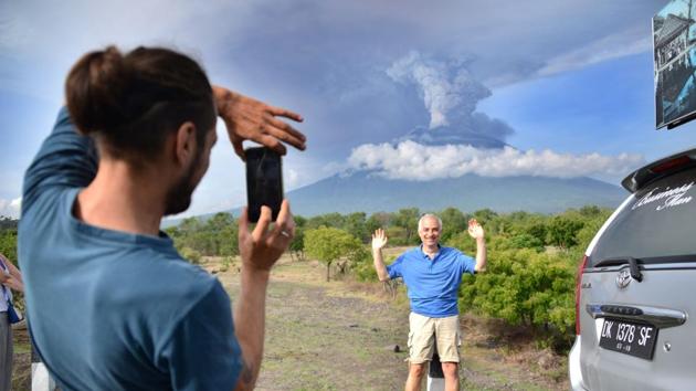 A tourist takes pictures in front of Mount Agung on November 27, 2017. An eruption could be imminent as the volcano belches huge plumes of smoke, officials warned. Spokesman Sutopo Purwo Nugroho said about 40,000 people have evacuated but others have not left because they feel safe or don’t want to abandon their livestock. (Sonny Tumbelaka / AFP) A tourist takes pictures in front of Mount Agung on November 27, 2017. An eruption could be imminent as the volcano belches huge plumes of smoke, officials warned. Spokesman Sutopo Purwo Nugroho said about 40,000 people have evacuated but others have not left because they feel safe or don’t want to abandon their livestock. (Sonny Tumbelaka / AFP)