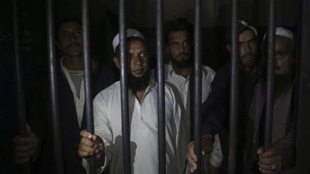 Relatives of a newly-wed couple stand behind bars at a police station in Karachi, Pakistan, Monday, Nov. 27, 2019. (AP) Relatives of a newly-wed couple stand behind bars at a police station in Karachi, Pakistan, Monday, Nov. 27, 2019. (AP)