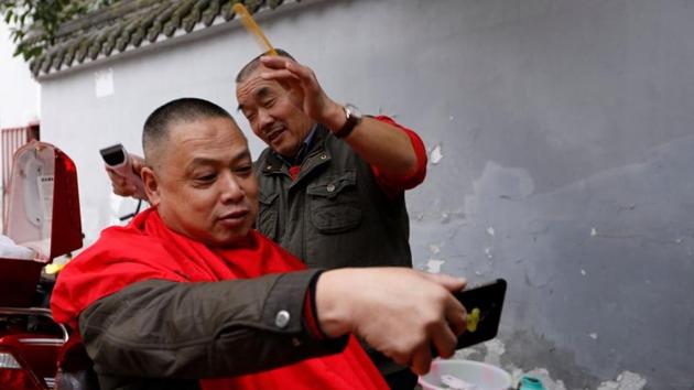 A customer takes a selfie with Xiong Gaowu (R) midway a trim in Chengdu. Customers swear by the practice of “blade wash eyes”, as it is known in Mandarin, saying they trust Xiong’s skill with the blade. Xiong learned the technique in the 1980s and serves up to eight customers a week, charging 80 yuan ($12) per shave. (Tyrone Siu / REUTERS) A customer takes a selfie with Xiong Gaowu (R) midway a trim in Chengdu. Customers swear by the practice of “blade wash eyes”, as it is known in Mandarin, saying they trust Xiong’s skill with the blade. Xiong learned the technique in the 1980s and serves up to eight customers a week, charging 80 yuan ($12) per shave. (Tyrone Siu / REUTERS)