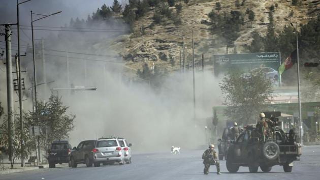 Smoke rises as security personnel stand guard near the Shamshad TV building after a deadly attack in Kabul, Afghanistan, on November 7.(AP file)