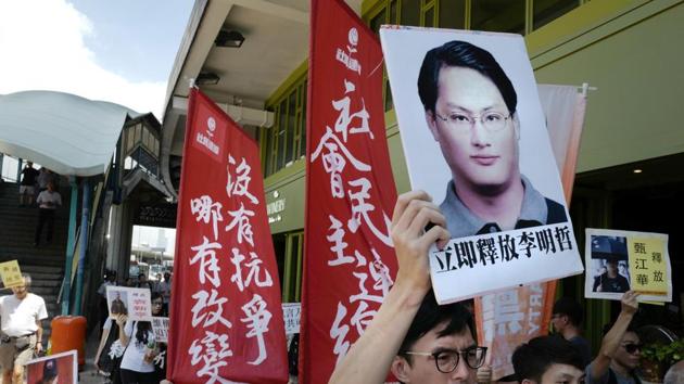 A protester raises a picture of Taiwanese activist Lee Ming-che during a demonstration outside the Chinese liaison office in Hong Kong.(AP File Photo)