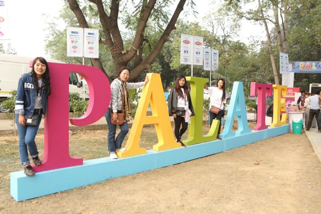 Youngsters strike a pose at the installation of Palate Fest placed at the entry of Nehru Park in Chanakyapuri.(MANOJ VERMA/ HT PHOTO)