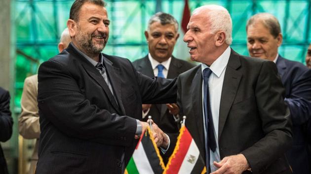 This file photo taken on October 12, 2017 shows Fatah's Azzam al-Ahmad (R) and Saleh al-Aruri (L) of Hamas shaking hands after signing a reconciliation deal in Cairo. Hamas, the Islamist movement that has run the Gaza Strip for a decade, has been seeking to end its long feud with Palestinian president Mahmud Abbas's Fatah, but its powerful armed wing may prove to be a dealbreaker. (AFP Photo) This file photo taken on October 12, 2017 shows Fatah's Azzam al-Ahmad (R) and Saleh al-Aruri (L) of Hamas shaking hands after signing a reconciliation deal in Cairo. Hamas, the Islamist movement that has run the Gaza Strip for a decade, has been seeking to end its long feud with Palestinian president Mahmud Abbas's Fatah, but its powerful armed wing may prove to be a dealbreaker. (AFP Photo)