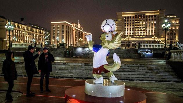Passers-by take pictures of a figure of Zabivaka, the official mascot for the 2018 FIFA World Cup.  (AFP) 